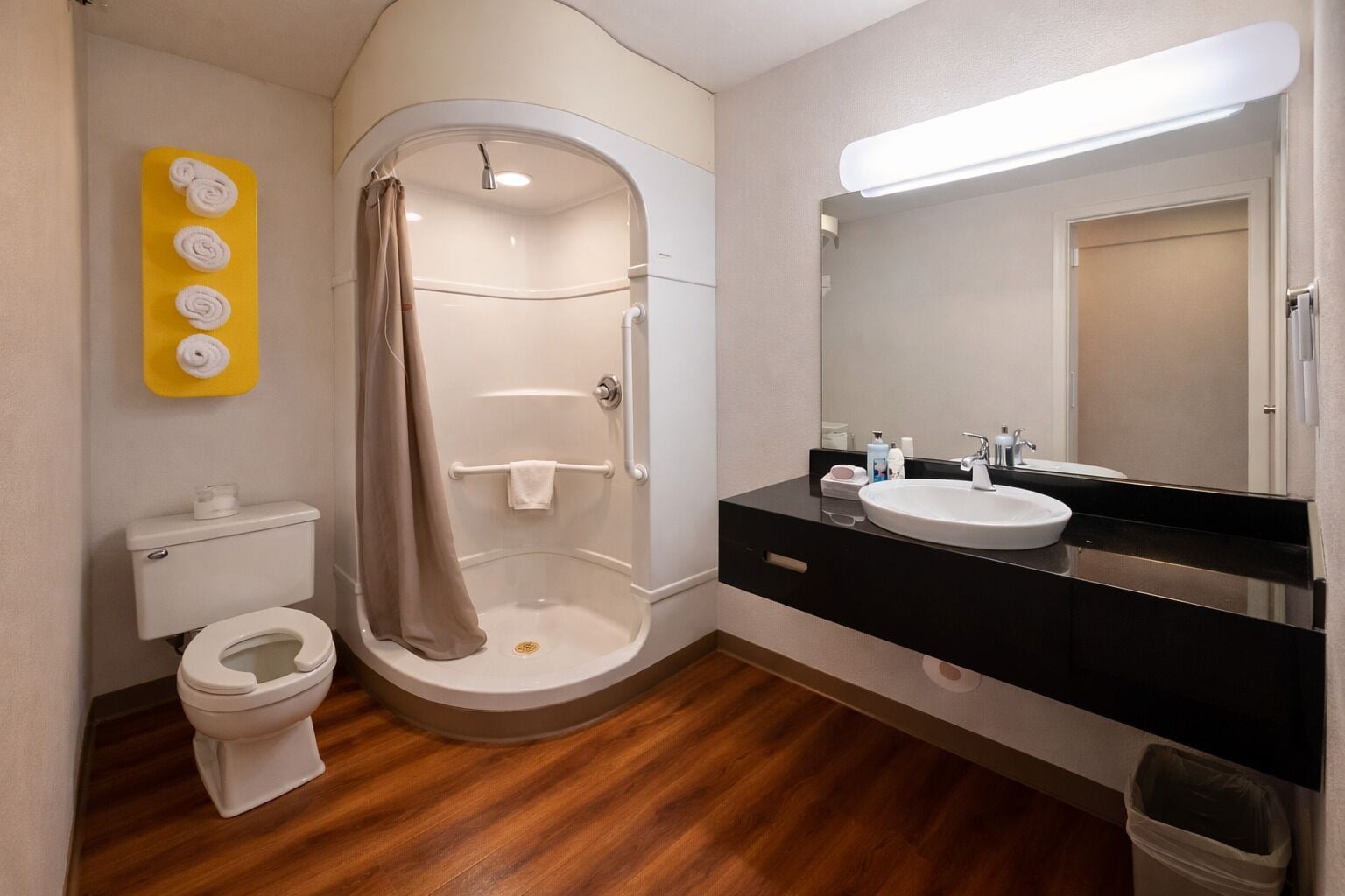A modern bathroom with a shower, toilet, and vanity.