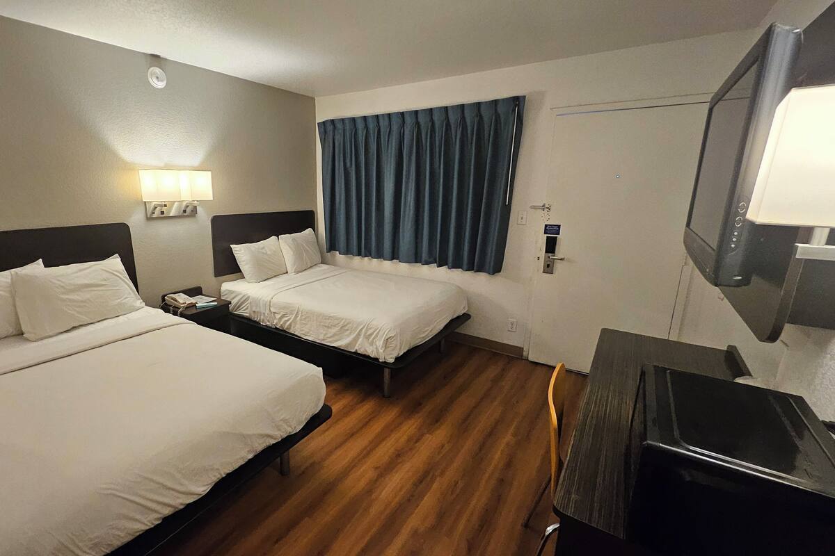 Cortinas blackout, tabla de planchar con plancha y ropa de cama