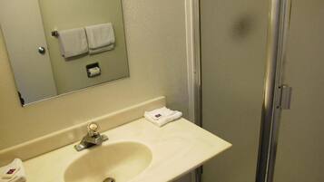 A bathroom with a sink, mirror, and a towel rack.