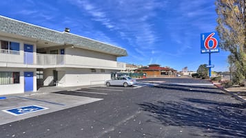 A motel with a parking lot, a handicapped parking space, and a sign indicating Wi-Fi availability.