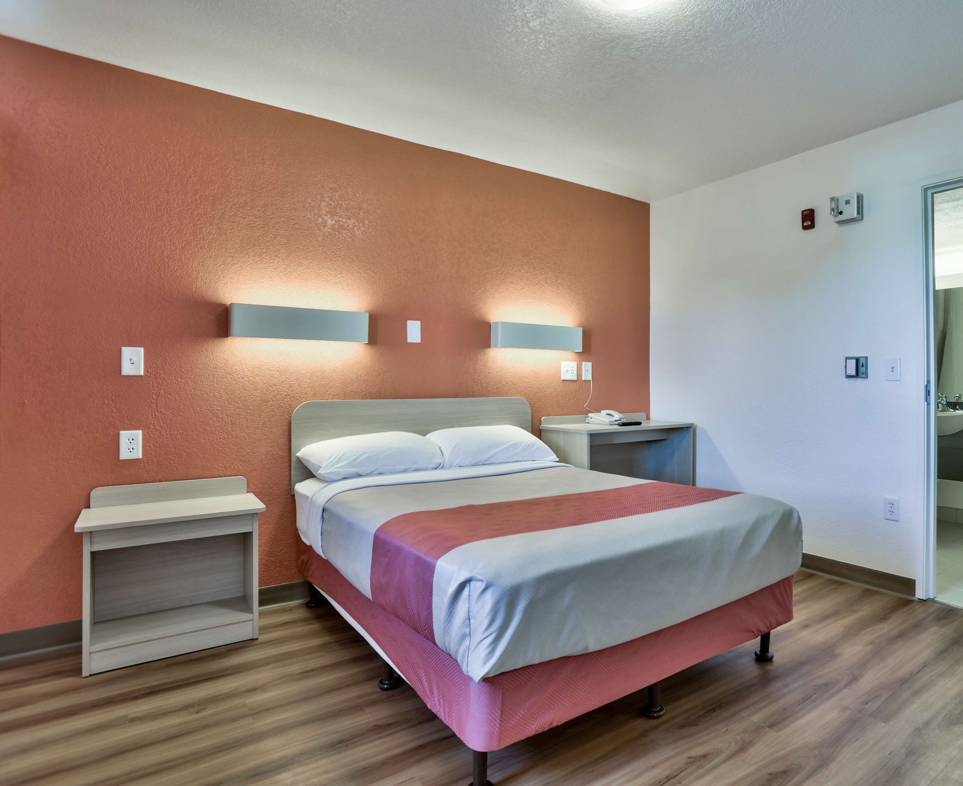 Une chambre d’hôtel avec un lit, des tables de chevet et une petite table de nuit.