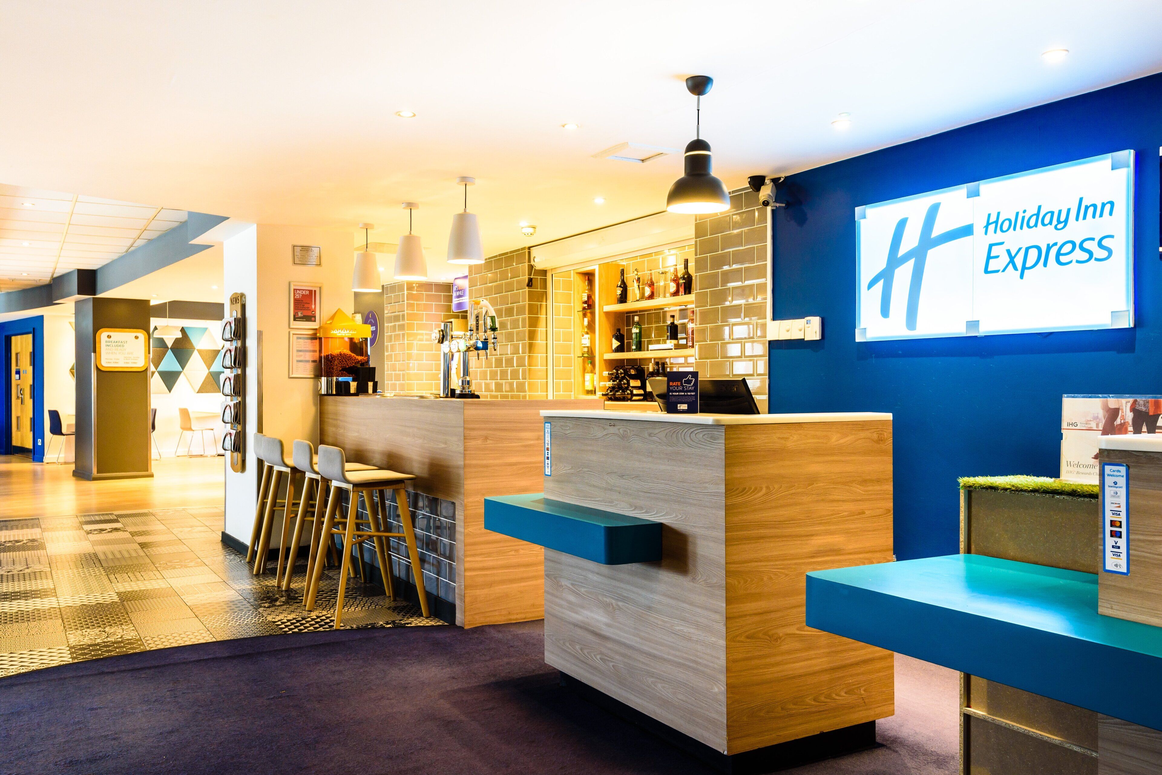 Een Holiday Inn Express lobby met een receptiebalie, een bar en zitplaatsen.