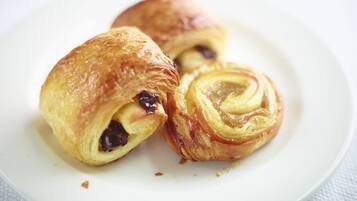 A plate with three pastries, one of which is cut open to reveal a filling.