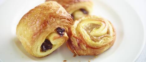 A plate with three pastries, one of which is cut open to reveal a filling.