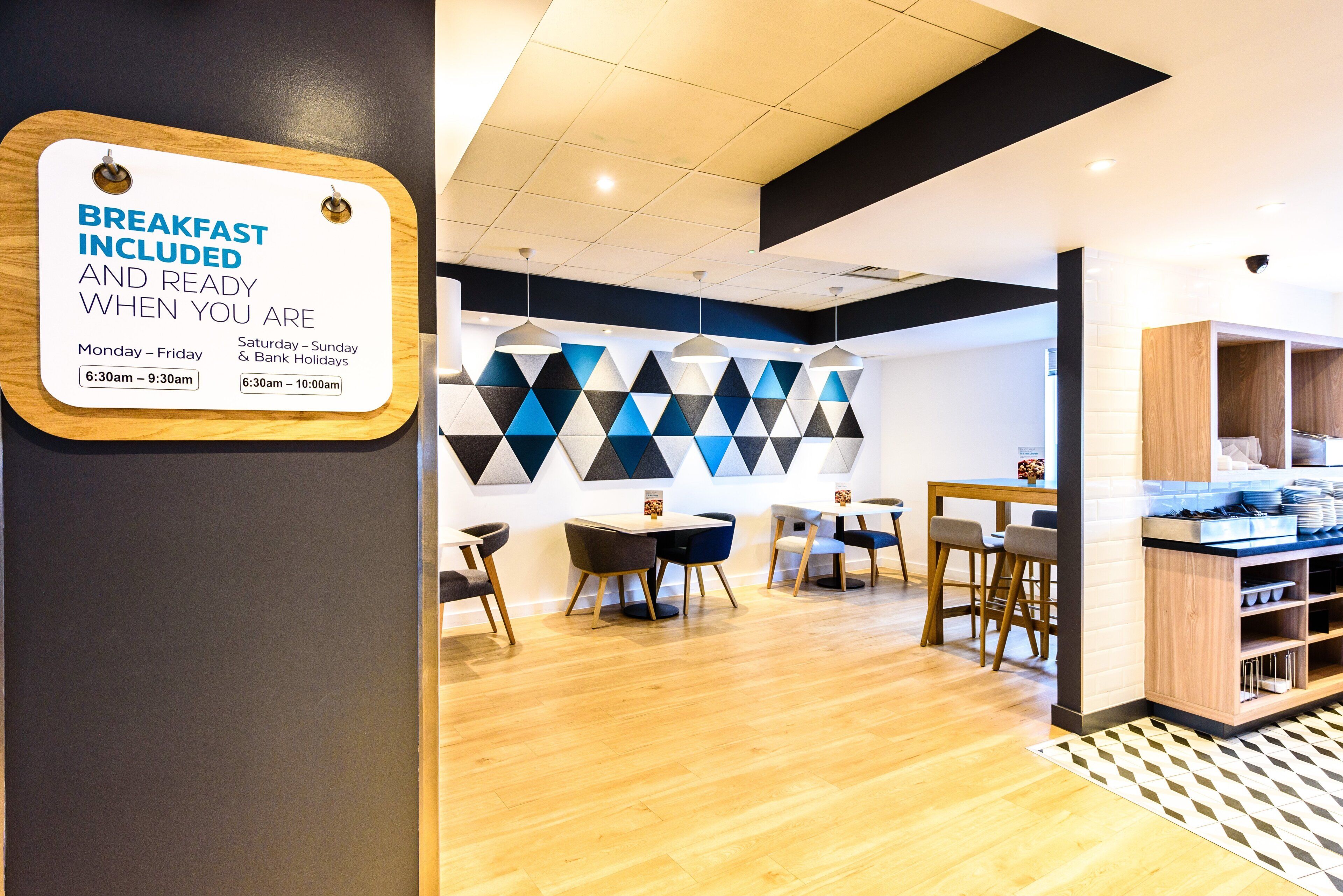 A breakfast area with a sign indicating breakfast hours.