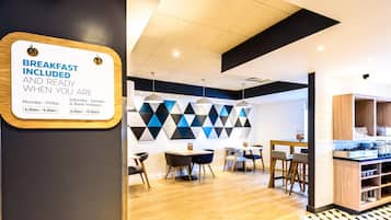 A breakfast area with a sign indicating breakfast hours.