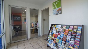 Un espace d’accueil doté d’une porte d’entrée en verre, d’un présentoir de brochures et d’une affiche faisant la publicité d’une application téléchargeable.