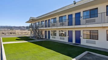A two-story building with a flat roof, multiple windows, and a staircase leading to the upper floor.