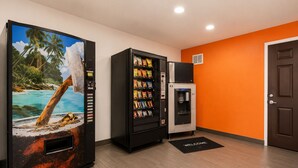 Een kamer met een grote koelkast, een automaat voor snacks en een waterdispenser.