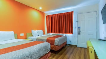 Habitación de hotel con dos camas, un escritorio y una televisión.