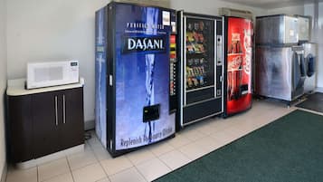 A row of vending machines with water, snacks, and Coca-Cola.