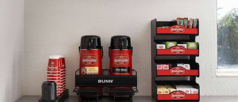 En kaffestation med två kaffebryggare, en kaffedispenser och ett urval av olika sorters kaffe och te.