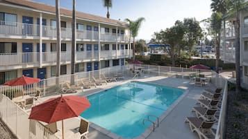 Relax by the pool surrounded by lounge chairs and umbrellas.