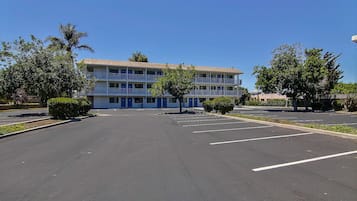 Un hotel su più piani con un parcheggio davanti.
