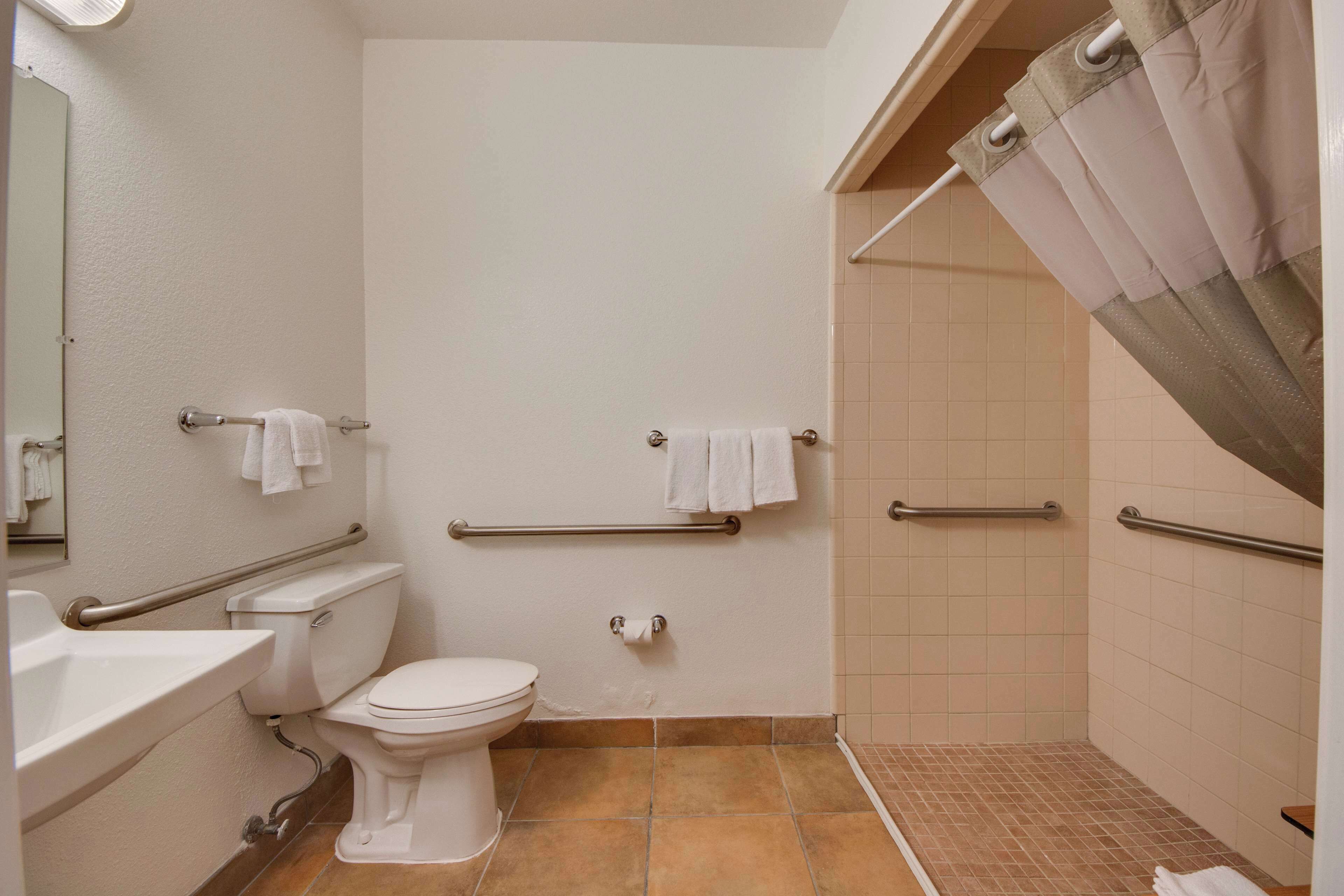 A bathroom with a toilet, sink, and shower area.