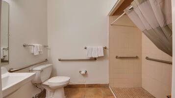 A bathroom with a toilet, sink, and shower area.