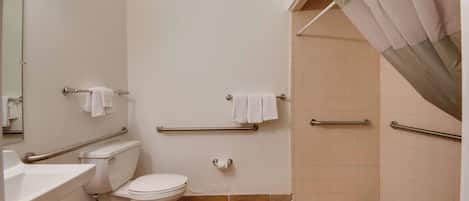 A bathroom with a toilet, sink, and shower area.
