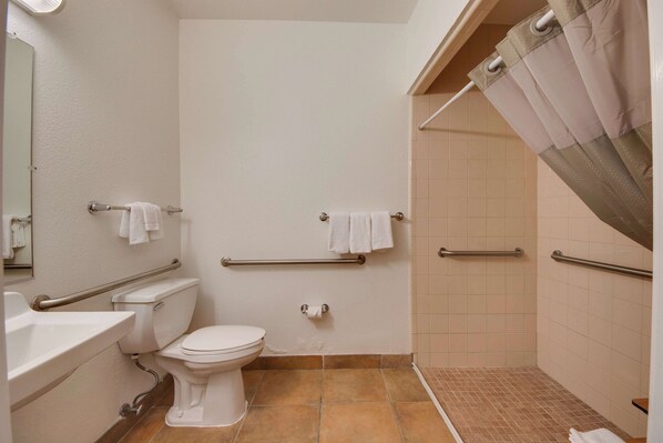 A bathroom with a toilet, sink, and shower area.
