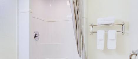 A bathroom with a shower, toilet, and towel rack.