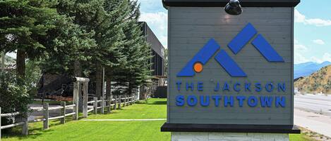 Un cartel para The Jackson Southtown con un diseño moderno, mostrando una vista de la montaña al fondo.