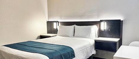 A hotel room with a bed, bedside tables, a desk, and a chair.