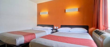 Habitación de hotel con dos camas, un teléfono en la pared y un equipo de aire acondicionado.
