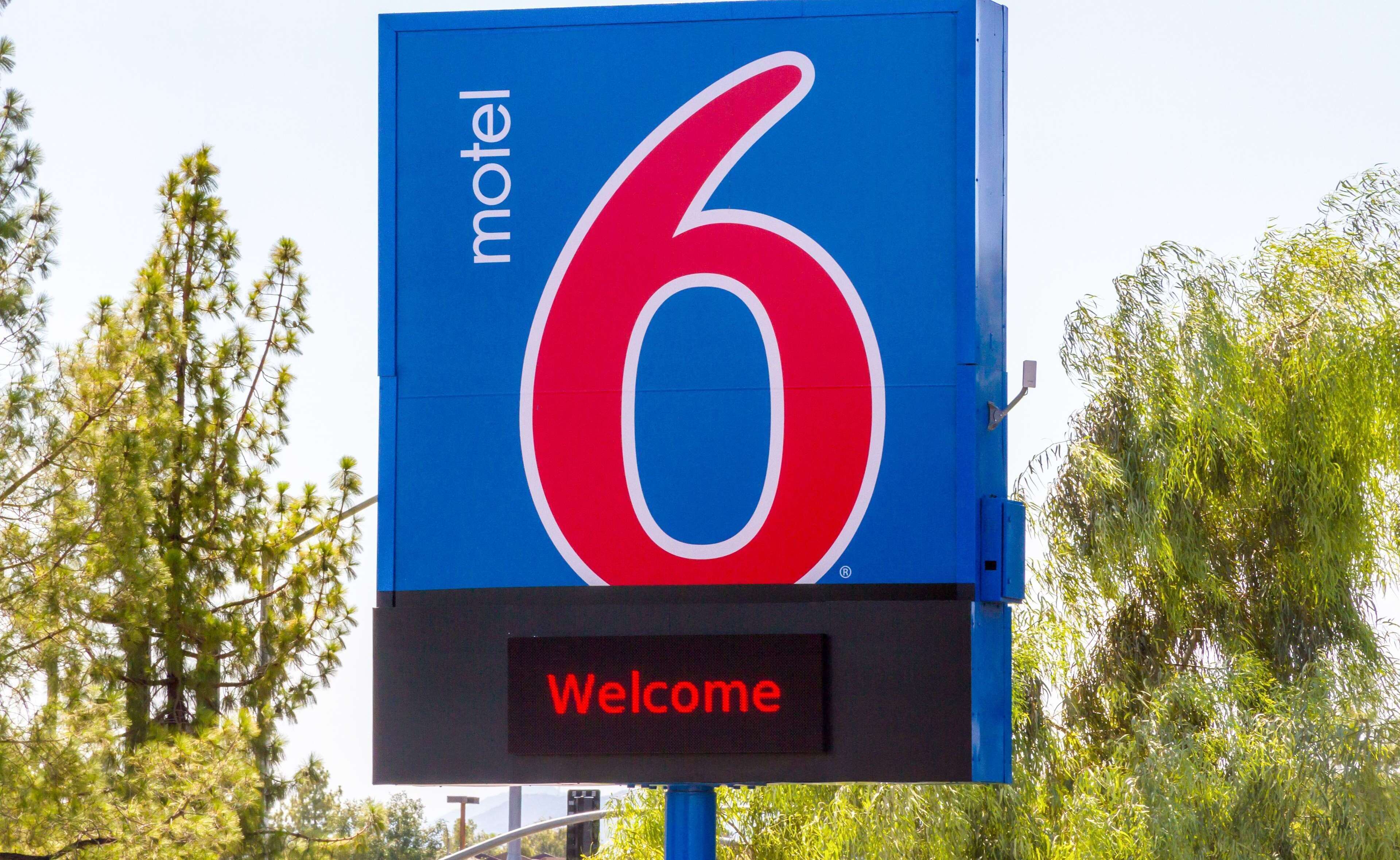 Señal de motel con el número 6 y un mensaje de bienvenida.