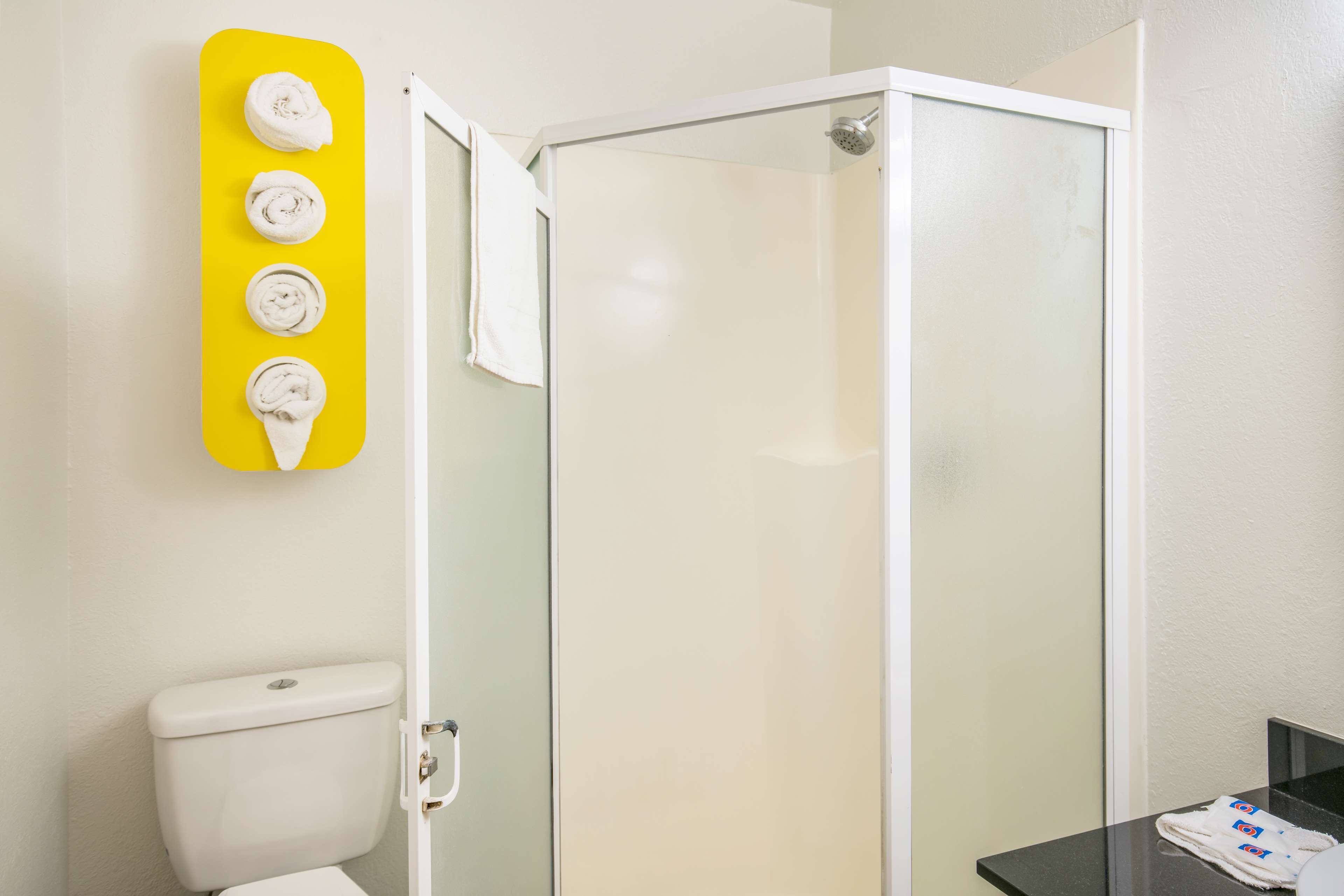 Un baño con cabina de ducha de vidrio, inodoro y lavabo con espejo.