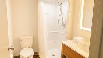A modern bathroom with a shower, toilet, and vanity.
