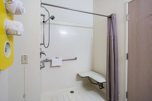 A bathroom with a shower, a toilet, and a bench. - Motel 6 Page, AZ (Page)