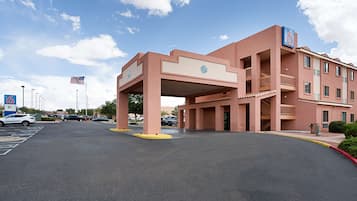 Un hôtel doté d’un grand parking, d’un drapeau et d’un panneau indiquant le chiffre « 6 ».