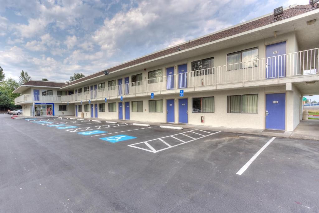 A motel with a parking lot, marked handicapped parking spaces, and a two-story building with balconies.