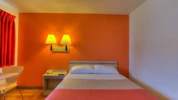 Habitación de hotel con cama, dos lámparas de noche, una mesita, una silla y una cortina roja.