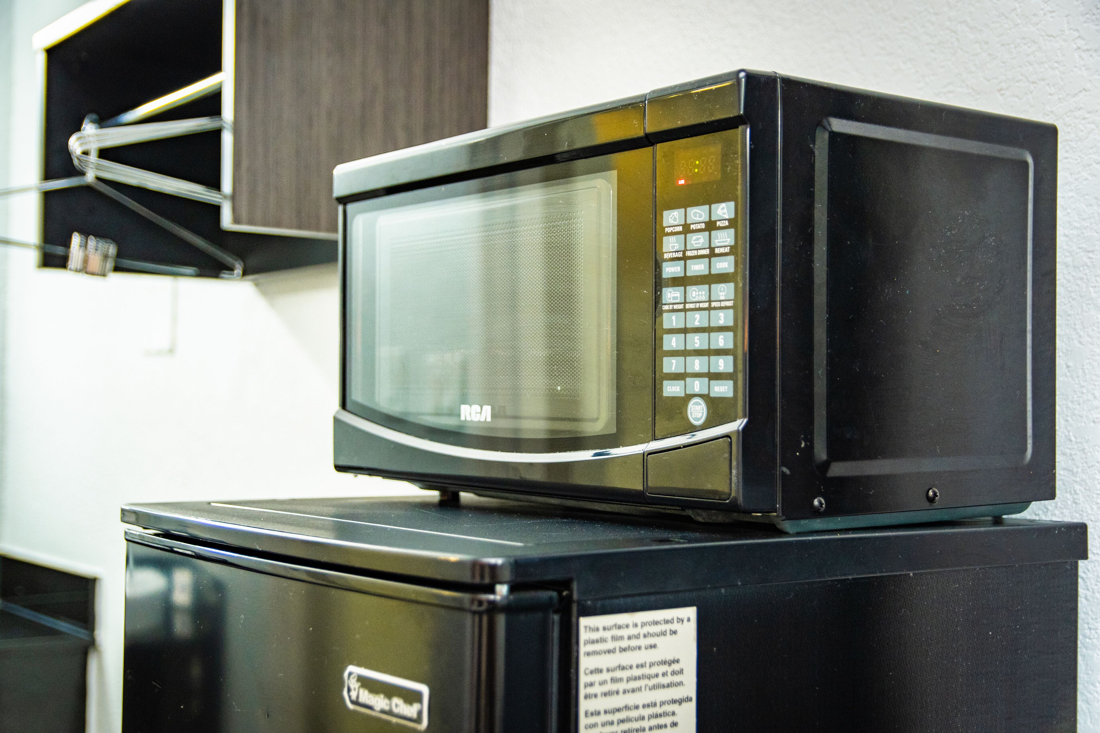 A microwave oven on top of a refrigerator.