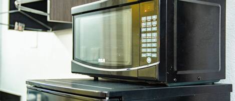A microwave oven on top of a refrigerator.