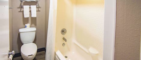 A bathroom with a toilet, a shower, and a bathtub.
