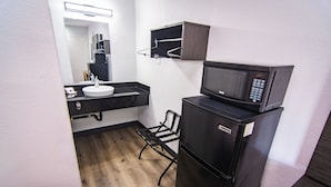 A compact kitchenette with a microwave, refrigerator, and sink.
