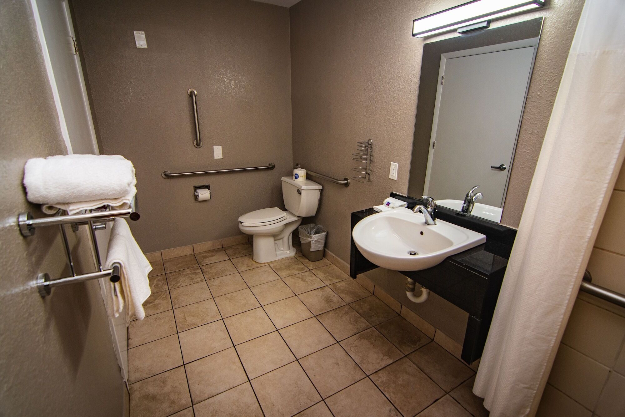 A bathroom with a toilet, sink, and towel rack.