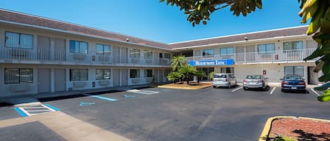 A motel with a parking lot, a sign for 'Rodeway Inn', and a building with multiple floors and balconies.