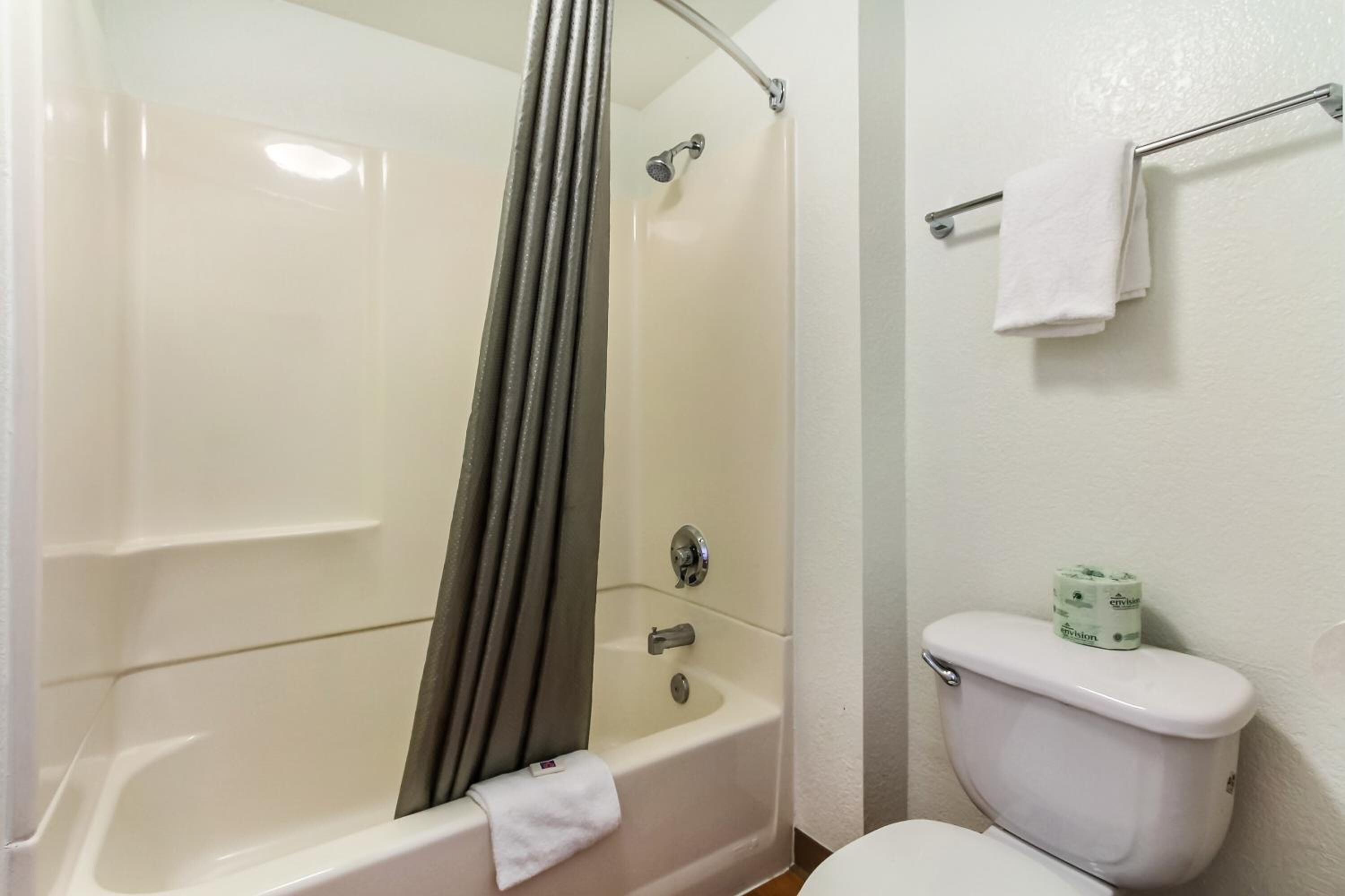 A bathroom with a bathtub, toilet, and towel rack.