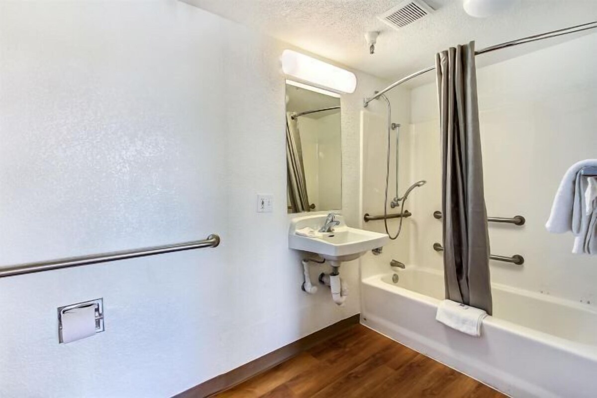 Une salle de bain équipée d’une douche, d’un lavabo et d’une barre d’appui.