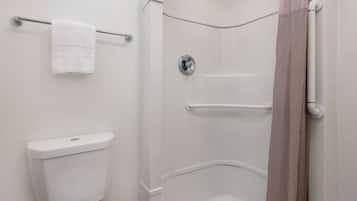 A bathroom with a toilet, a shower with a grab bar, and a towel rack.