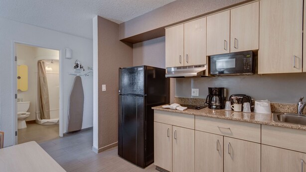 A modern kitchen with a refrigerator, microwave, and coffee maker. - Studio 6 El Paso, TX - East (El Paso)