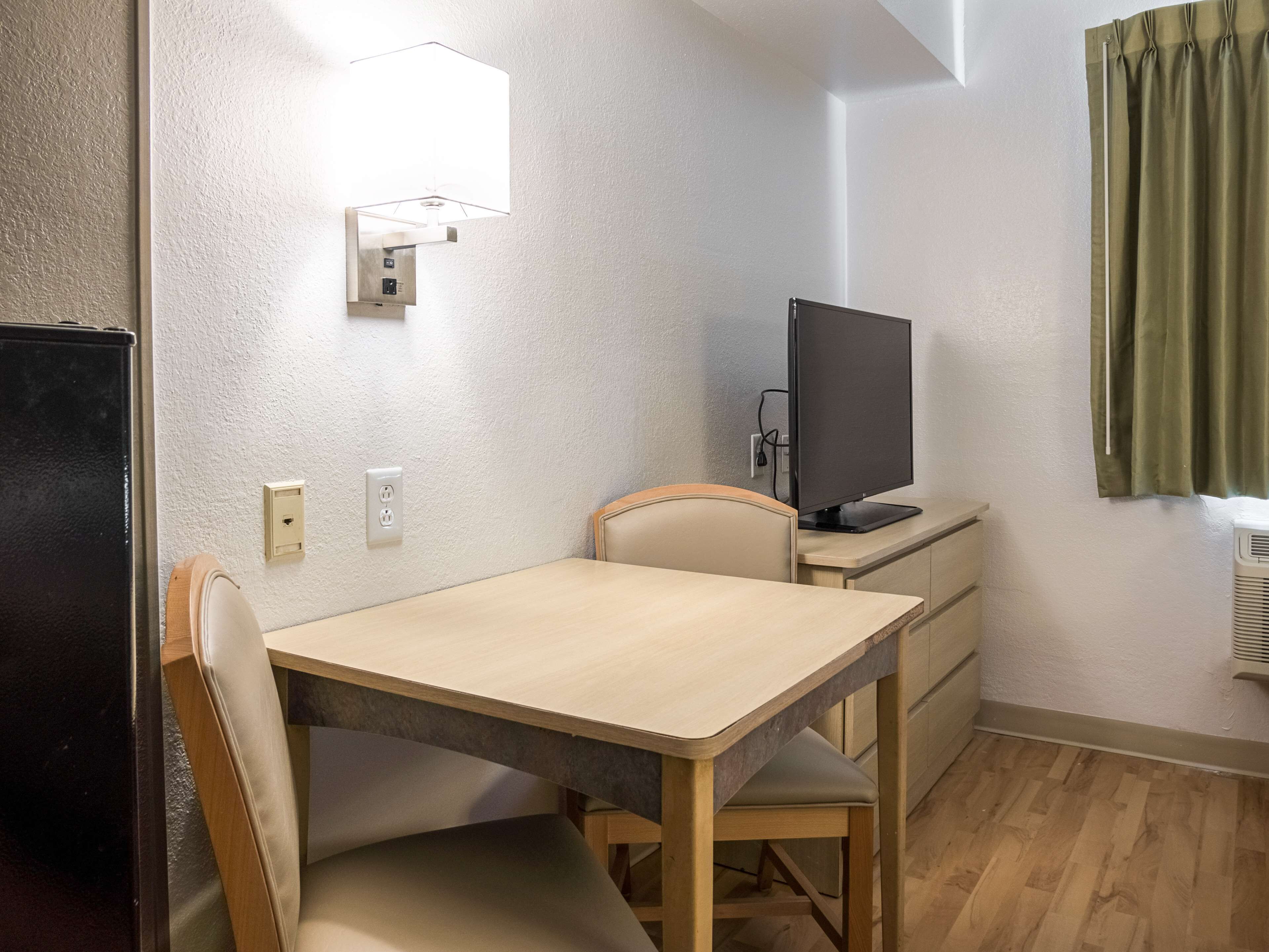 Skrivebord, sengetøy og vekkerklokke