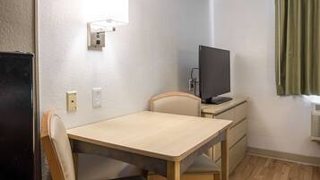 Skrivebord, sengetøy og vekkerklokke