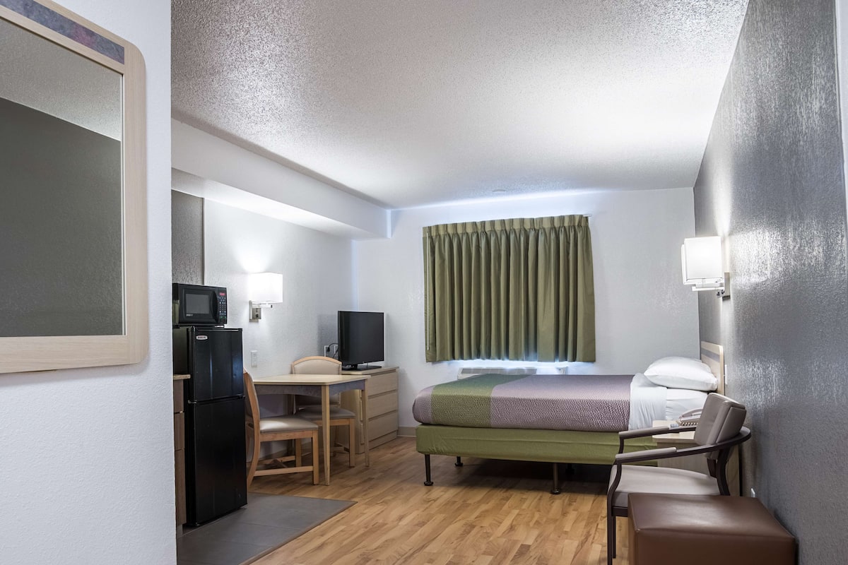 Skrivebord, sengetøy og vekkerklokke