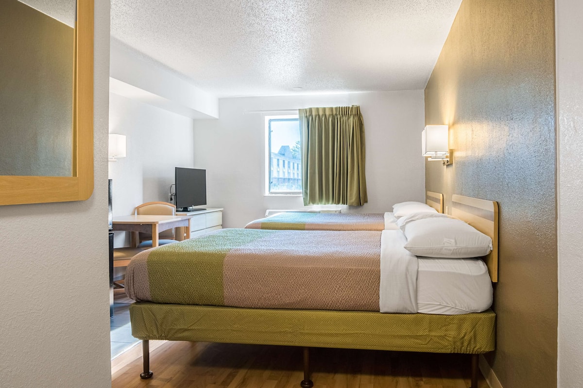 Skrivebord, sengetøy og vekkerklokke