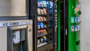 Un distributeur automatique de collations et une pancarte indiquant la présence de glaçons.