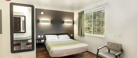 Skrivebord, strykejern/-brett, sengetøy og vekkerklokke