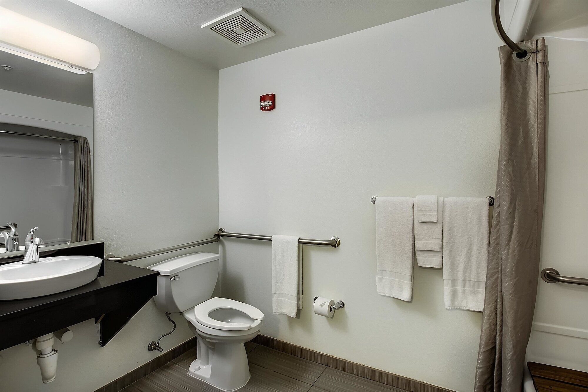 A bathroom with a toilet, sink, and shower curtain.